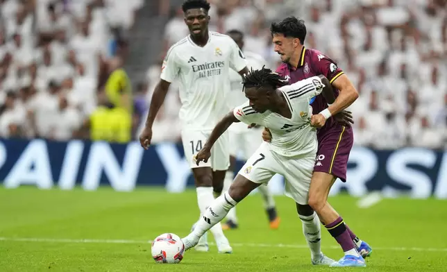 Valladolid's Kike Perez, right, and Real Madrid's Vinicius Junior challenge for the ball during the Spanish La Liga soccer match between Real Madrid and Valladolid at the Santiago Bernabeu stadium in Madrid, Spain, Sunday, Aug. 25, 2024. (AP Photo/Manu Fernandez)