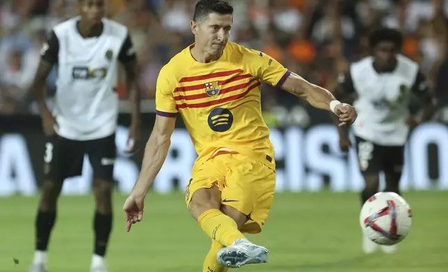 Barcelona's Robert Lewandowski scores his side's second goal by a penalty shot during the Spanish La Liga soccer match between Valencia and FC Barcelona at the Mestalla stadium in Valencia, Spain, Saturday, Aug. 17, 2024. (AP Photo/Alberto Saiz)