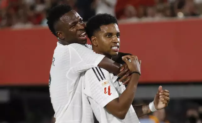 Real Madrid's Rodrygo, right, celebrates with Vinicius Junior after scoring the opening goal during a Spanish La Liga soccer match between Mallorca and Real Madrid at the Son Moix Stadium in Palma de Mallorca, Spain, Sunday, Aug. 18, 2024. (AP Photo/Francisco Ubilla)