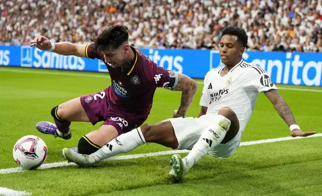 Real Madrid's Rodrygo, right, and Valladolid's Luis Perez challenge for the ball during the Spanish La Liga soccer match between Real Madrid and Valladolid at the Santiago Bernabeu stadium in Madrid, Spain, Sunday, Aug. 25, 2024. (AP Photo/Manu Fernandez)