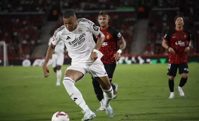 Real Madrid's Kylian Mbappe runs with the ball during a Spanish La Liga soccer match between Mallorca and Real Madrid at the Son Moix Stadium in Palma de Mallorca, Spain, Sunday, Aug. 18, 2024. (AP Photo/Francisco Ubilla)