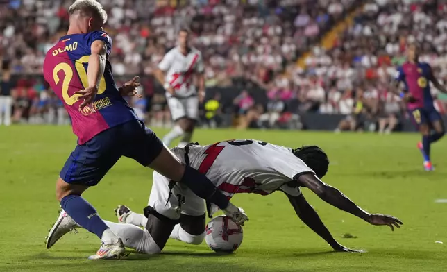 Barcelona's Dani Olmo, left, challenges for the ball with Rayo's Abdul Mumin during the Spanish La Liga soccer match between Rayo Vallecano and Barcelona at the Vallecas stadium in Madrid, Spain, Tuesday, Aug. 27, 2024. (AP Photo/Manu Fernandez)
