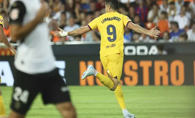 Barcelona's Robert Lewandowski celebrates after scoring his side's second goal during the Spanish La Liga soccer match between Valencia and FC Barcelona at the Mestalla stadium in Valencia, Spain, Saturday, Aug. 17, 2024. (AP Photo/Alberto Saiz)