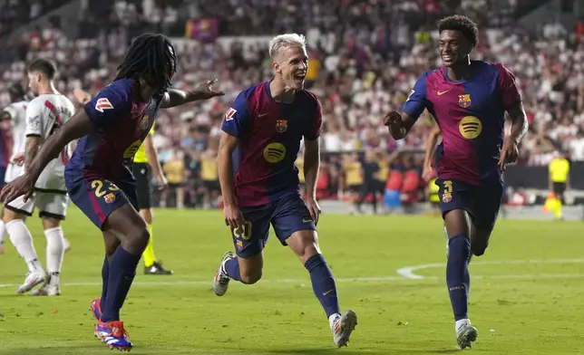 Barcelona's Dani Olmo, centre, celebrates after scoring his side's second goal during the Spanish La Liga soccer match between Rayo Vallecano and Barcelona at the Vallecas stadium in Madrid, Spain, Tuesday, Aug. 27, 2024. (AP Photo/Manu Fernandez)