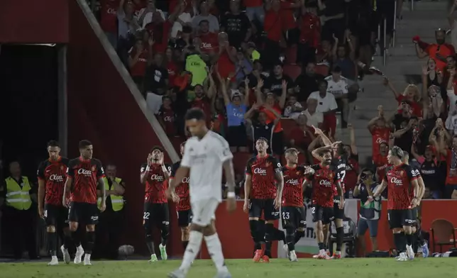 Real Madrid's Rodrygo walks back as Mallorca players celebrate after Vedat Muriqi scored his side's first goal during a Spanish La Liga soccer match between Mallorca and Real Madrid at the Son Moix Stadium in Palma de Mallorca, Spain, Sunday, Aug. 18, 2024. (AP Photo/Francisco Ubilla)