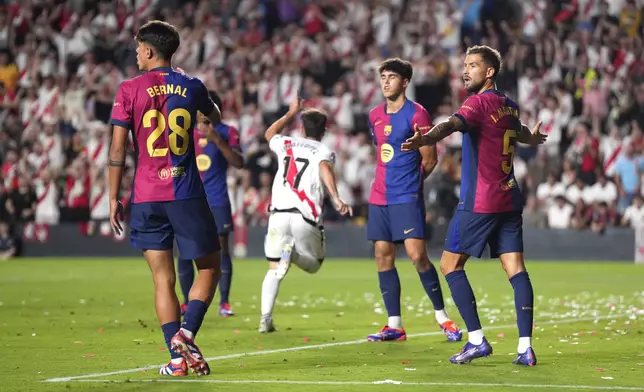 Barcelona players react as Rayo's Unai Lopez celebrates after scoring his side's opening goal during the Spanish La Liga soccer match between Rayo Vallecano and Barcelona at the Vallecas stadium in Madrid, Spain, Tuesday, Aug. 27, 2024. (AP Photo/Manu Fernandez)