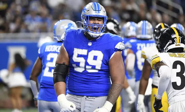 Detroit Lions offensive tackle Giovanni Manu reacts after a teammate's touchdown during the first half of an NFL preseason football game against the Pittsburgh Steelers, Saturday, Aug. 24, 2024, in Detroit. (AP Photo/Jose Juarez)