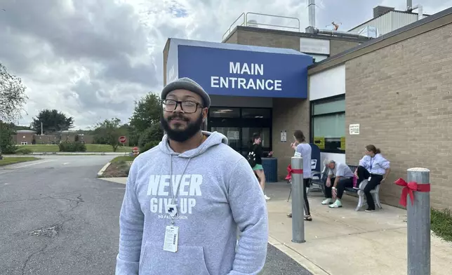 Michael Santos, a security guard, stands outside the Nashoba Valley Medical Center in Ayer, Mass., on Friday, Aug. 9, 2024. (AP Photo/Nick Perry)