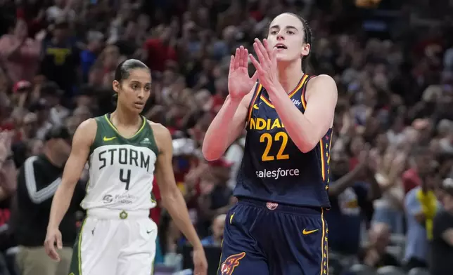 Indiana Fever's Caitlin Clark (22) reacts in front of Seattle Storm's Skylar Diggins-Smith (4) during the second half of a WNBA basketball game, Sunday, Aug. 18, 2024, in Indianapolis. (AP Photo/Darron Cummings)