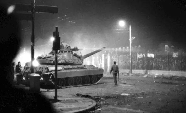 FILE- Army tanks prepare to drive through the gates of the student-occupied Polytechnic Institute, in Athens, Nov. 17, 1973. (AP photo/File)