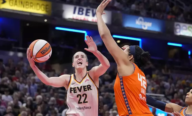 Indiana Fever guard Caitlin Clark (22) shot over Connecticut Sun forward Brionna Jones (42) in the second half of a WNBA basketball game in Indianapolis, Wednesday, Aug. 28, 2024. (AP Photo/Michael Conroy)