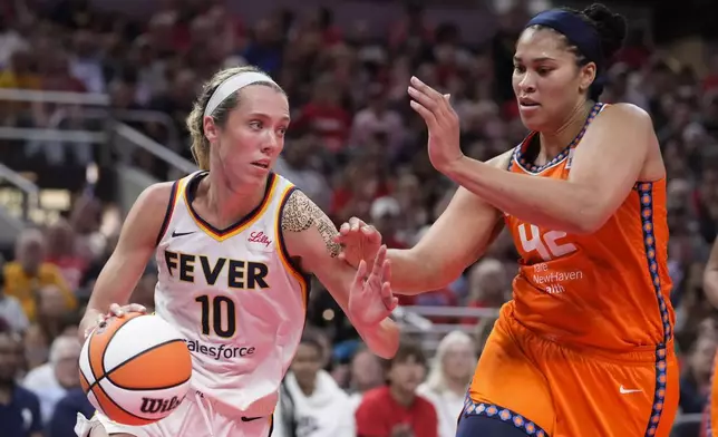 Indiana Fever guard Lexie Hull (10) drives on Connecticut Sun forward Brionna Jones (42) in the second half of a WNBA basketball game in Indianapolis, Wednesday, Aug. 28, 2024. (AP Photo/Michael Conroy)