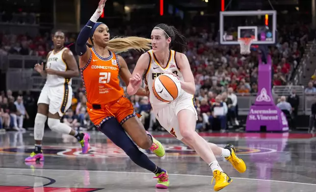 Indiana Fever guard Caitlin Clark (22) drives on Connecticut Sun guard DiJonai Carrington (21) in the second half of a WNBA basketball game in Indianapolis, Wednesday, Aug. 28, 2024. (AP Photo/Michael Conroy)