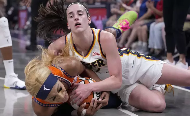 Indiana Fever guard Caitlin Clark, top, and Connecticut Sun guard DiJonai Carrington (21) go to the floor for a loose ball in the second half of a WNBA basketball game in Indianapolis, Wednesday, Aug. 28, 2024. (AP Photo/Michael Conroy)