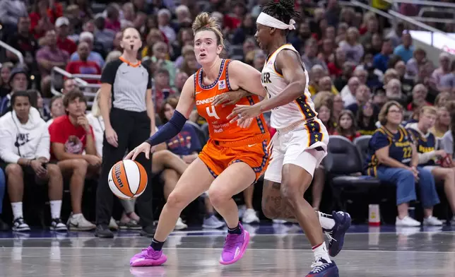 Connecticut Sun guard Marina Mabrey (4) drives on Indiana Fever guard Erica Wheeler (17) in the first half of a WNBA basketball game in Indianapolis, Wednesday, Aug. 28, 2024. (AP Photo/Michael Conroy)