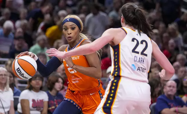 Connecticut Sun guard DiJonai Carrington (21) drives on Indiana Fever guard Caitlin Clark (22) in the first half of a WNBA basketball game in Indianapolis, Wednesday, Aug. 28, 2024. (AP Photo/Michael Conroy)