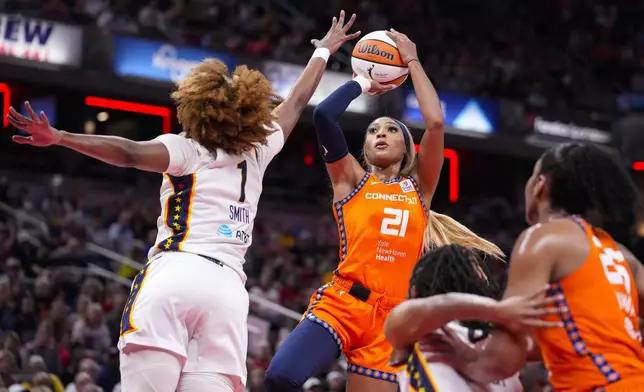 Connecticut Sun guard DiJonai Carrington (21) shoots over Indiana Fever forward NaLyssa Smith (1) in the first half of a WNBA basketball game in Indianapolis, Wednesday, Aug. 28, 2024. (AP Photo/Michael Conroy)