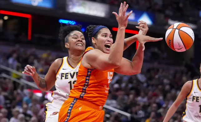 Indiana Fever forward Damiris Dantas (12) knocks the ball away from Connecticut Sun forward Brionna Jones (42) in the first half of a WNBA basketball game in Indianapolis, Wednesday, Aug. 28, 2024. (AP Photo/Michael Conroy)