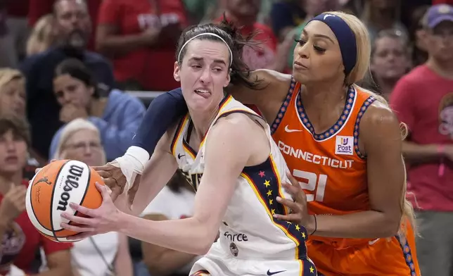 Connecticut Sun guard DiJonai Carrington (21) fouls Indiana Fever guard Caitlin Clark (22) in the second half of a WNBA basketball game in Indianapolis, Wednesday, Aug. 28, 2024. (AP Photo/Michael Conroy)