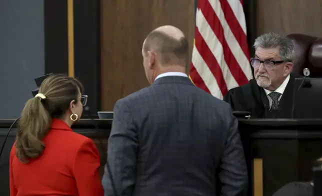 Galveston County Court No. 3 Judge Jack Ewing speaks with attorneys Lori Laird, left, and Clint McGuire before a recess in the civil trial against the parents of accused Santa Fe High School shooter Dimitrios Pagourtzis on Wednesday, July 31, 2024, at the Galveston County Courthouse in Galveston, Texas. (Jennifer Reynolds/The Galveston County Daily News via AP, Pool)