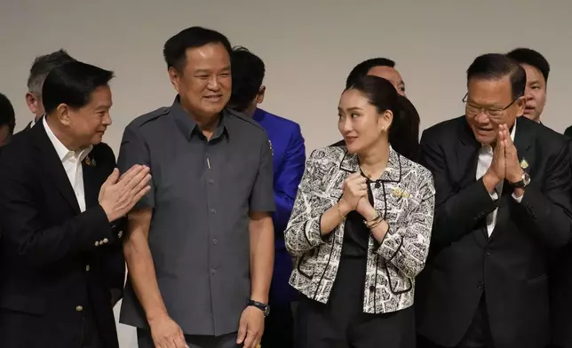 Leader of Pheu Thai Party, Paetongtarn Shinawatra, daughter of Thailand's former Prime Minister Thaksin Shinawatra, third form left, and coalition partners smiles during press conference in Bangkok, Thailand, Thursday, Aug. 15, 2024. (AP Photo/Sakchai Lalit)