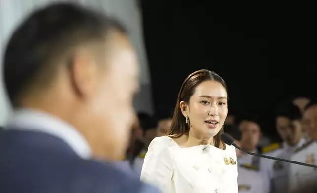 Thailand's new Prime Minister Paetongtarn Shinawatra, right, and former Thai Prime Minister Srettha Thavisin, left, talk to media members after receiving the royal endorsement for the post, Sunday, Aug. 18, 2024, at the Pheu Thai party headquarters in Bangkok, Thailand. (AP Photo/Sakchai Lalit)