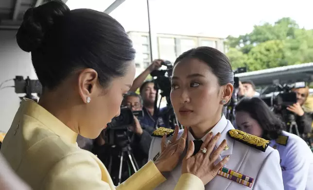 Pinthongta Shinawatra, left, adjusts a tie of her younger sister and Thailand's newly elected Prime Minister Paetongtarn Shinawatra before the royal endorsement ceremony appointing Paetongtarn as Thailand's new prime minister at Pheu Thai party headquarters in Bangkok Sunday, Aug. 18, 2024. (AP Photo/Sakchai Lalit)