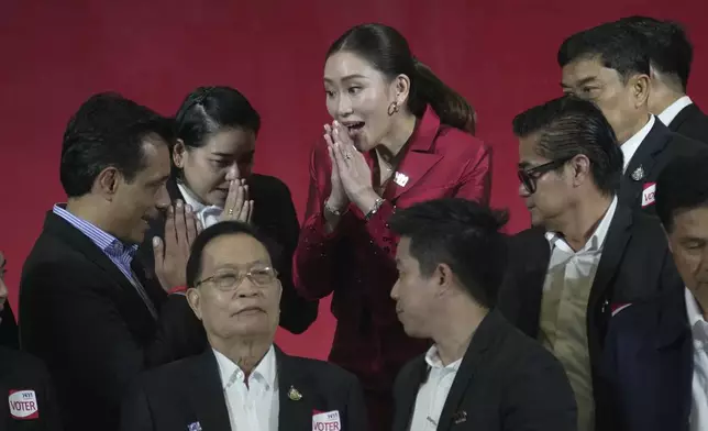 FILE- New leader of Pheu Thai Party, Paetongtarn Shinawatra, center, daughter of Thailand's former Prime Minister Thaksin Shinawatra, offers a traditional greeting known as a "wai" to member of Pheu Thai Party at the party headquarters in Bangkok, Thailand, Friday, Oct. 27, 2023. (AP Photo/Sakchai Lalit, File)