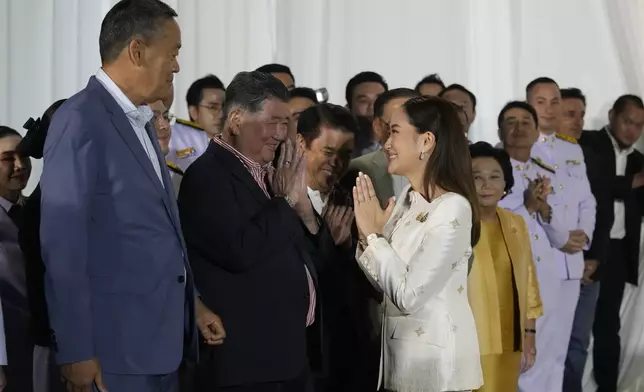 Thailand's new Prime Minister Paetongtarn Shinawatra, right, pays respect to former Thai Prime Minister Srettha Thavisin, left, after receiving the royal endorsement for the post, Sunday, Aug. 18, 2024, at the Pheu Thai party headquarters in Bangkok, Thailand. (AP Photo/Sakchai Lalit)