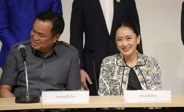 Leader of Pheu Thai Party, Paetongtarn Shinawatra, daughter of Thailand's former Prime Minister Thaksin Shinawatra, right, and coalition partners smile during a press conference in Bangkok, Thailand, Thursday, Aug. 15, 2024. (AP Photo/Sakchai Lalit)