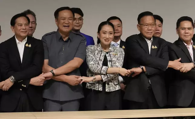 Leader of Pheu Thai Party, Paetongtarn Shinawatra, daughter of Thailand's former Prime Minister Thaksin Shinawatra, third form left, and coalition partners shake hand during press conference in Bangkok, Thailand, Thursday, Aug. 15, 2024. (AP Photo/Sakchai Lalit)