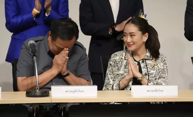 Leader of Pheu Thai Party, Paetongtarn Shinawatra, daughter of Thailand's former Prime Minister Thaksin Shinawatra, right, and coalition partners guture during press conference in Bangkok, Thailand, Thursday, Aug. 15, 2024. (AP Photo/Sakchai Lalit)