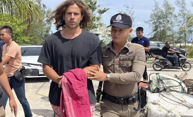 FILE - A Thai police officer escorts Spanish Daniel Sancho Bronchalo on suspicion of murdering and dismembering a Colombian surgeon from Koh Phagnan island to Koh Samui Island court, southern Thailand, Monday, Aug. 7, 2023. (AP Photo/Somkeat Ruksaman, File )