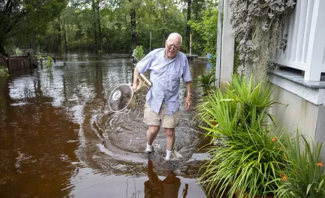 Charles Grainger cleans up around his house in the historic district of French Quarter Creek as flood waters recede from Tropical Storm Debby, Wednesday, Aug. 7, 2024, in Huger, S.C. (AP Photo/Mic Smith)