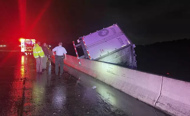 A tractor trailer dangles from a bridge on Interstate 75 near Tampa, Fla., early Monday, Aug. 5, 2024. The driver was killed. The truck’s cab broke off and dropped into the Tampa Bypass Canal. Sheriff’s office divers located the 64-year-old man from New Albany, Mississippi in the cab 40 feet below the surface, according to the Florida Highway Patrol.(Florida Highway Patrol via AP)