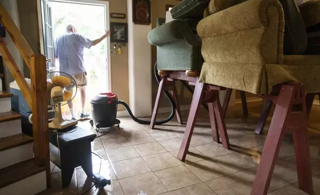 Charles Grainger cleans up around his house in the historic district of French Quarter Creek as flood waters recede from Tropical Storm Debby, Wednesday, Aug. 7, 2024, in Huger, S.C. (AP Photo/Mic Smith)