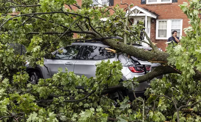 A vehicle is covered by a tree in Harrisburg, Pa., after extreme weather from Tropical storm Debby, Friday, Aug. 9, 2024. (Sean Simmers/The Patriot-News via AP)