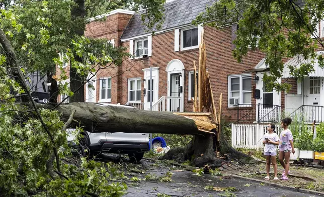 Children survey damage on Adrian Street in Harrisburg, Pa., after extreme weather from Tropical storm Debby, Friday, Aug. 9, 2024. (Sean Simmers/The Patriot-News via AP)