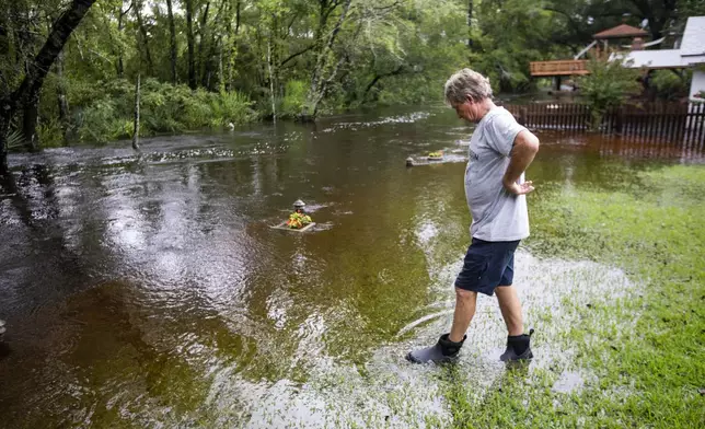 Gene Taylor watches the flood waters around his house in the historic district of French Quarter Creek as flood waters recede from Tropical Storm Debby, Wednesday, Aug. 7, 2024, in Huger, S.C. (AP Photo/Mic Smith)