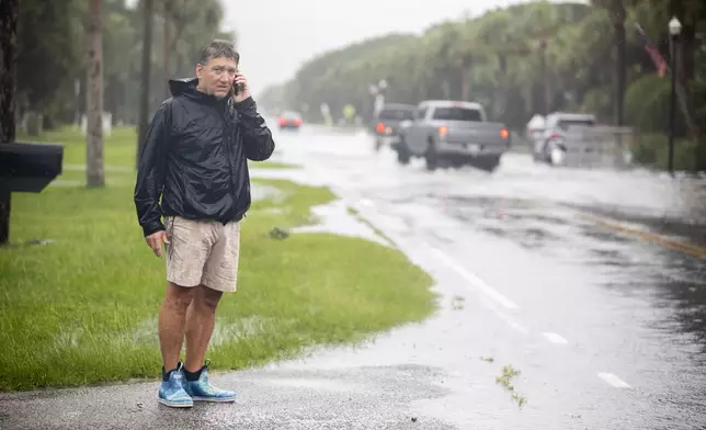 City of Isle of Palms councilman John Bogosian calls local officials informing them flooding water on Palm Blvd as Tropical Storm Debby approaches, Tuesday, Aug. 6, 2024, in Isle of Palms, S.C. (AP Photo/Mic Smith)