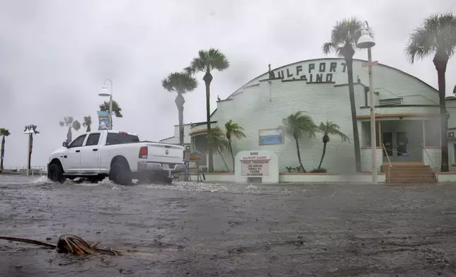 A vehicle drives through a flooded street as Tropical Storm Debby approaches Florida, on Sunday, Aug. 4, 2024 in Gulfport, Fla. (Dylan Townsend/Tampa Bay Times via AP)