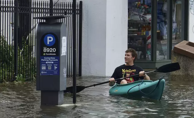 Will Sizemore kayaks in a flooded area near the City Dock in Annapolis, Md., on Friday, Aug. 9, 2024. (Kaitlin Newman/The Baltimore Banner via AP)