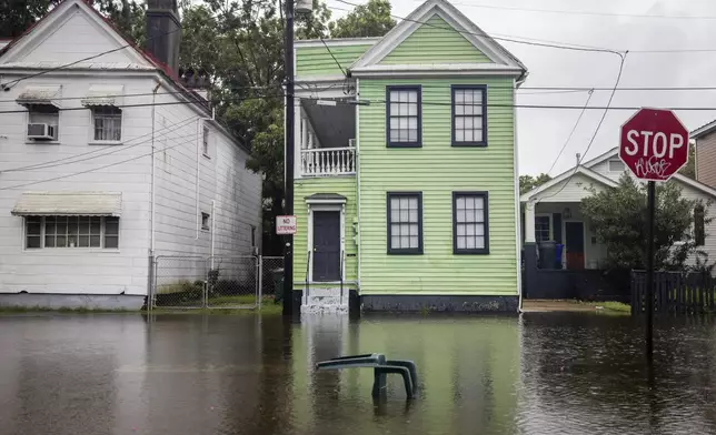 A lawn chair floats at the intersection of Aiken Street and North Hampstead Square street as rain continues to fall from Tropical Storm Debby, Tuesday, Aug. 6, 2024, in Charleston, S.C. (Gavin McIntyre/The Post And Courier via AP)