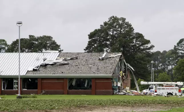 Parts of Springfield Middle School lay on the ground after being ripped off by a tornado, spawned by Tropical Storm Debby, in Lucama, N.C., Thursday, Aug. 8, 2024. (AP Photo/Makiya Seminera)