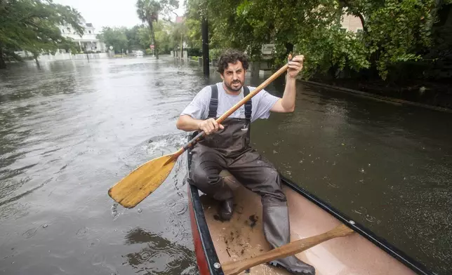 Trip Hamilton, from Charleston, S.C., canoes down Ashley Ave in Charleston as Tropical Storm Debby approaches, Tuesday, Aug. 6, 2024. (AP Photo/Mic Smith)