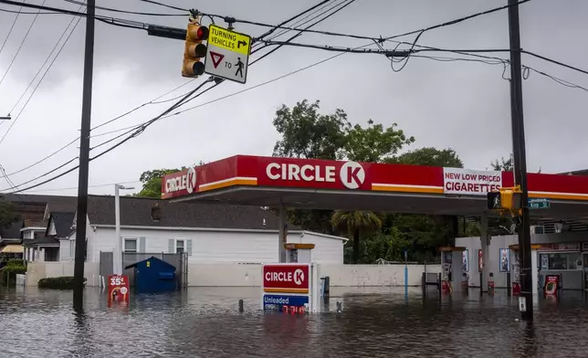 Flood waters overtake the intersection of Huger Street and King street as rain continues to fall from Tropical Storm Debby, Tuesday, Aug. 6, 2024, in Charleston, S.C. (Henry Taylor/The Post And Courier via AP)