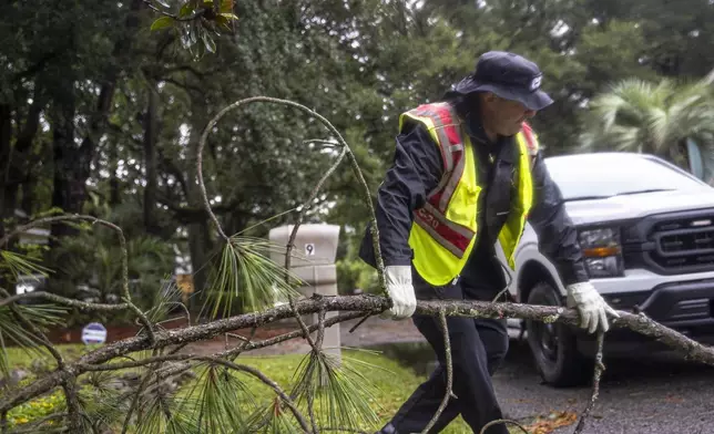 Colin Fanning the Battalion Chief-Safety and Professional Development for the Hilton Head Island Fire Rescue removes a fallen branch as he patrols the island as Tropical Storm Debby passes by Hilton Head Island, S.C., Tuesday, Aug. 6, 2024. (Andrew Whitaker/The Post And Courier via AP)