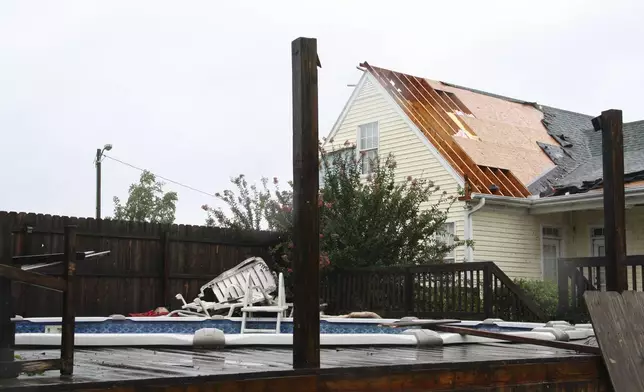 Part of the roof of Genesis Cooper's home is shown blown off after a tornado, spawned by Tropical Storm Debby, passed through Lucama, N.C., on Thursday, Aug. 8, 2024. (AP Photo/Makiya Seminera)