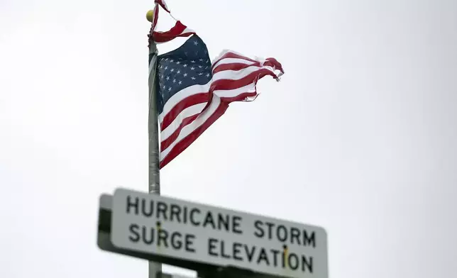 An American flag is nearly shredded from the winds from Tropical Storm Debby, Tuesday, Aug. 6, 2024, in Tybee Island, Ga. (AP Photo/Stephen B. Morton)