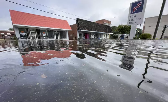 Residual rain water floods the downtown area caused by Tropical Storm Debby, Thursday, Aug. 8, 2024, in Bladenboro, NC. (AP Photo/John Minchillo)